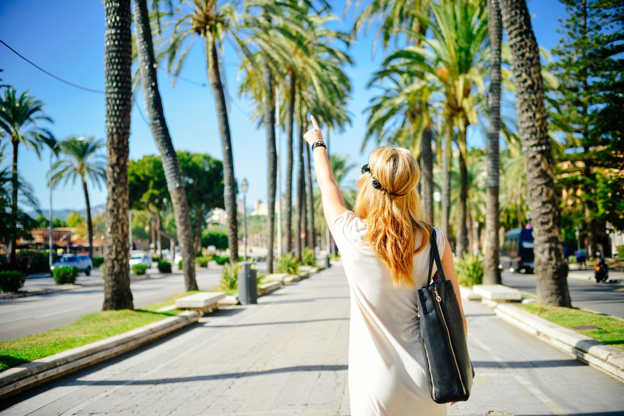 Woman on a retreat pointing at palm trees.