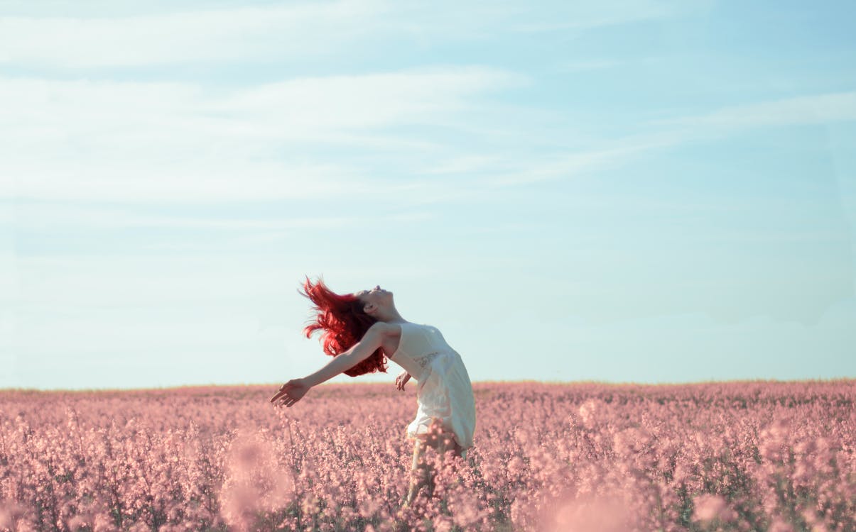 Woman dancing in pink flower field