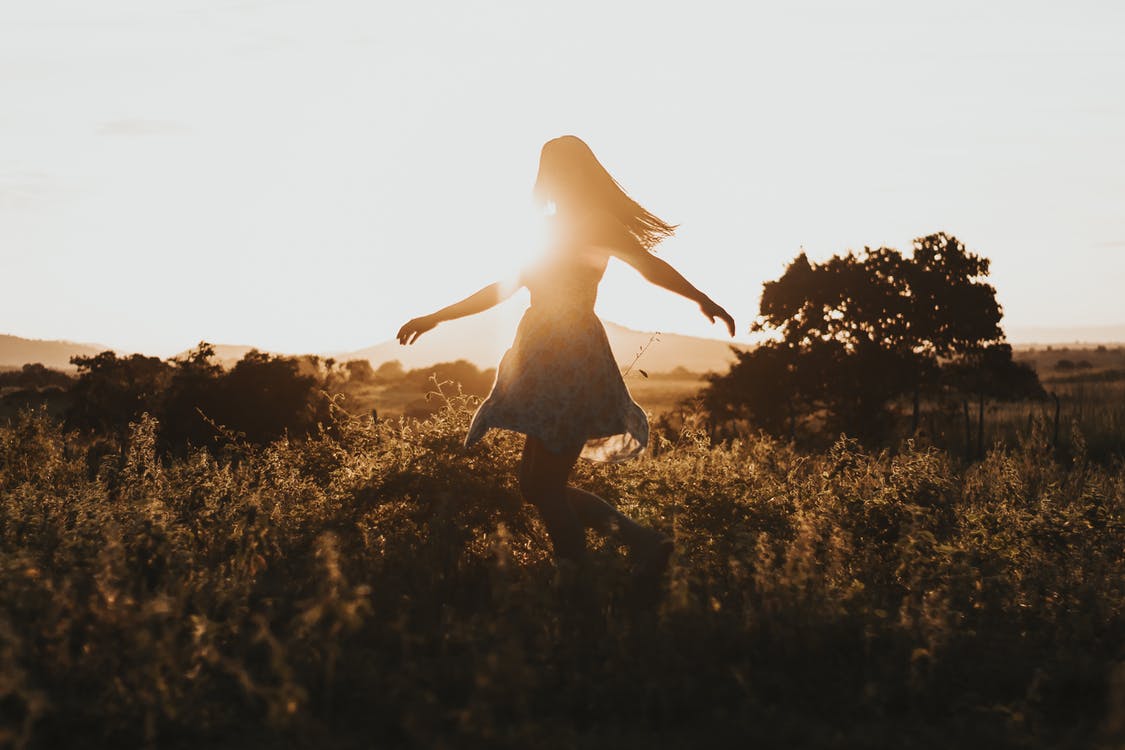 Woman frolicking outside happily.